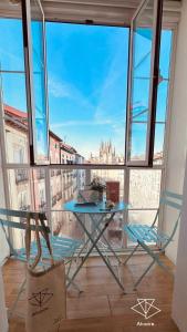 a table and chairs in a room with a large window at Atuaire Home Preciosa vivienda Vistas a la Catedral Parking Incluido in Burgos