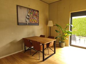 a dining room table with chairs and a painting on the wall at Tiny Loft Hunsrück in Sohren