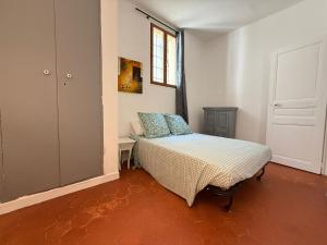 a bedroom with a bed and a window and a door at F2 au cœur du centre ville in Perpignan