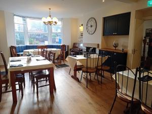 a dining room with tables and chairs and a clock on the wall at Salmon Leap Hotel in Whitby
