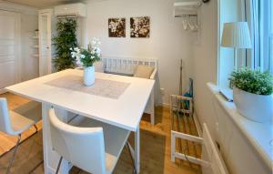 a dining room with a white table and chairs at 2 Bedroom Lovely Home In Köpingsvik in Köpingsvik