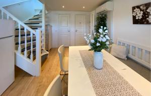 a room with a table with a vase of flowers on it at 2 Bedroom Lovely Home In Köpingsvik in Köpingsvik