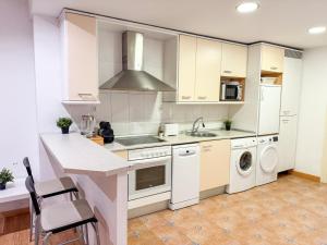 Una cocina con gabinetes blancos y un horno de estufa. en Canal del Pilar - Turistea, en Zaragoza