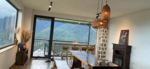 a dining room with a table and a large window at Homestay 1579 SaPa in Sapa