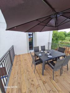 a black table and chairs on a deck with an umbrella at Apartment Zaglav in Zaglav