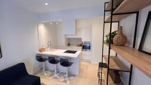 a kitchen with a sink and a counter with stools at Andreas and Nelly in Thessaloniki +13 photos