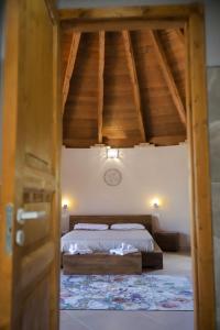 a bedroom with a bed and a wooden ceiling at Pinnettu Sa Rosa - Sardinian Hideaway by HIHE in Quartu Sant'Elena