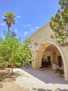 an archway in a building with a palm tree at Agriturismo Antares in San Foca