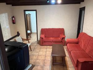 a living room with a red couch and a chair at La Cerezal II in Borines