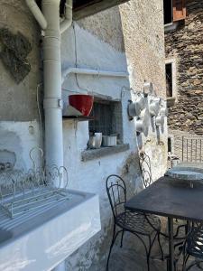 d'une terrasse avec une table, des chaises et un four. dans l'établissement Bnbook Ca Du Val, à Falmenta