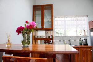 a vase of flowers on a table in a kitchen at Earthy Inn in Pretoria +13 photos