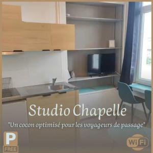 a kitchen with a sink and a tv on a shelf at Studio Chapelle in Dunkerque