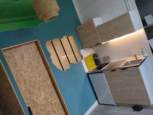 a small kitchen with a sink and a blue wall at Studio Chapelle in Dunkerque