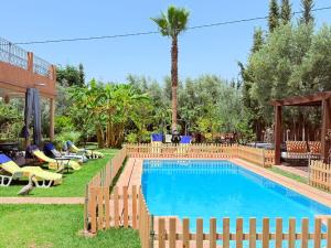a swimming pool with a wooden fence around it at Villa avec Piscine Chauffée Privée pour Familles in Marrakesh