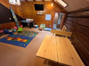 a living room with a wooden table and a bench at Chata Mir in Dolní Bečva