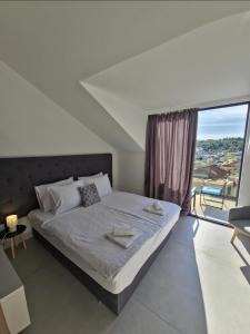 a bedroom with a bed and a large window at Aura Maris Sutivan in Sutivan