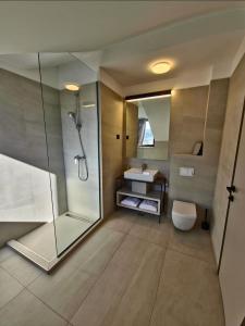 a bathroom with a shower and a toilet and a sink at Aura Maris Sutivan in Sutivan