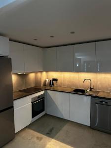 a kitchen with white cabinets and stainless steel appliances at Apartamento Punta Prima in Torrevieja