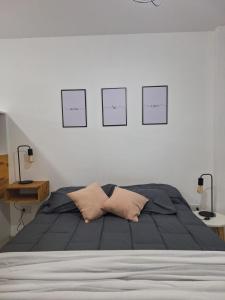 a bedroom with a bed with four pictures on the wall at Amoblado Carlos I in Río Cuarto