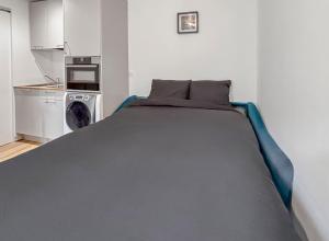 a large bed in a room with a kitchen at Confort & calme proche Marne in Champigny-sur-Marne +14 photos