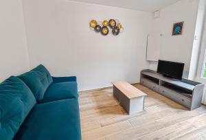 a living room with a blue couch and a tv at Confort & calme proche Marne in Champigny-sur-Marne