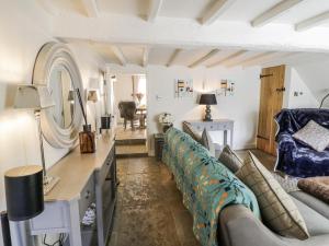 a living room with a couch and a table at Cotstone Cottage in Chipping Campden