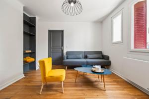 sala de estar con sofá, mesa y silla amarilla en T3 Appartement au centre ville, en Annecy