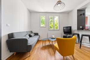 sala de estar con sofá gris y silla amarilla en T3 Appartement au centre ville, en Annecy