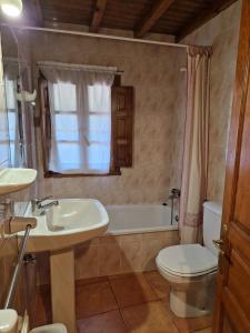 a bathroom with a sink and a toilet and a tub at La Cerezal I in Borines