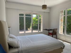滨海博利厄Villa vue mer Beaulieu的带床、书桌和窗户的卧室