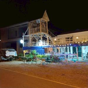 a large building with tables and chairs at night at Aran hostel Spa&Cafe Riverside That Phanom in Amphoe That Phanom