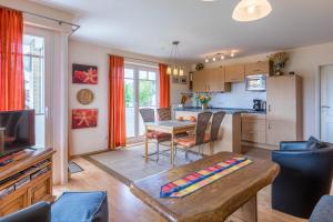 a living room with a table and a kitchen at Haus Undine Wohnung 09 in Boltenhagen +20 photos