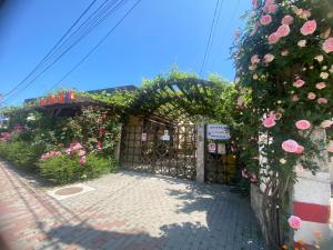 an entrance to a garden with flowers on a fence at Casa Double M, Vama Veche in Vama Veche