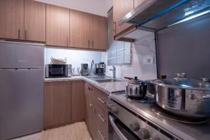 a kitchen with wooden cabinets and a stove top oven at Vadina Apartment 2 in Xirokástellon