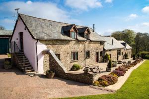 a large stone building with a staircase in front of it at West Hollowcombe Farm Cottages - full site in Dulverton