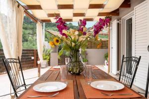 a table with a vase of flowers on a porch at Vadina Apartment 2 in Xirokástellon