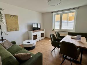 a living room with a couch and a table at Komfortables Innenstadt-Apartment WOLF - Zentrumlage in Sankt Pölten