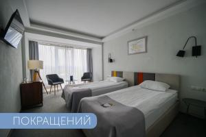 a hotel room with two beds and a window at Black Sea Central in Odesa
