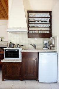 a kitchen with a sink and a stove top oven at Aposperitis Village in Theodhóra