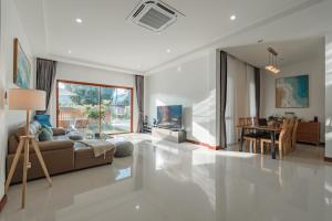 ein Wohnzimmer mit Sofa und Tisch in der Unterkunft New Pakbia Private Pool Villa 3 Bed Ao Nang Krabi in Ban Chong Phli