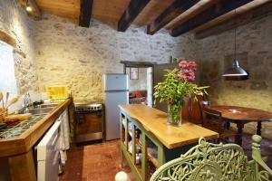 a kitchen with a table with a vase of flowers on it at Maison en pierre à Laroque-Timbaut - Clévacances 3 clés in Laroque-Timbaut +11 photos