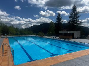 Una gran piscina con montañas al fondo. en Koruna, en Tatariv