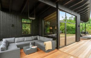 a living room with a gray couch and glass doors at Beautiful Home In Børkop With Sauna in Børkop +20 photos