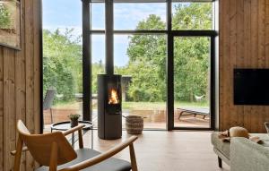 a living room with a fireplace in front of a large window at Beautiful Home In Børkop With Sauna in Børkop