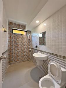 a bathroom with a toilet and a sink at Phuiyara Resort in Nakhon Nayok