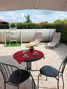 a patio with a table and chairs and an umbrella at Al giardino nascosto in Visco +4 photos
