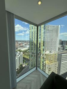 a room with a large window with a view of a city at The Banks - Private Luxury 2-Bed Flat Manchester Central in Manchester