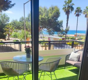 a balcony with a table and chairs and the ocean at SeaHomes Vacations - Seafront Mediterranean Ap & PKG in Blanes