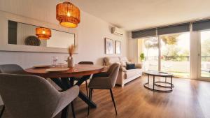 a living room with a table and chairs at SeaHomes Vacations - Seafront Mediterranean Ap & PKG in Blanes