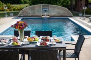 The Teplice Aqua Villa by Aura Luxury Collection في تبليتسه: طاولة بها أطباق طعام بجوار حمام السباحة